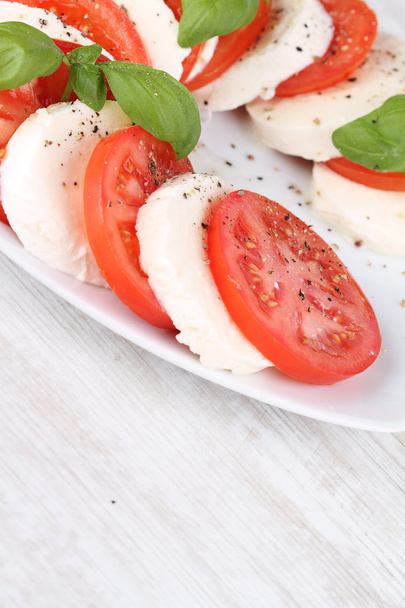 Salade de tomates et mozzarella aux feuilles de basilic
 - Photo, image