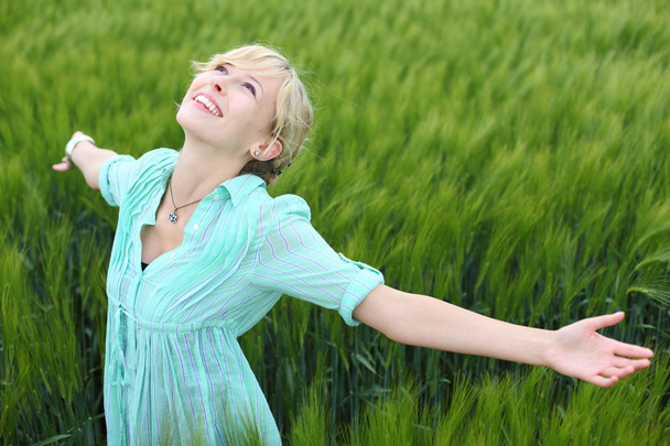 Pretty woman rejoicing in a green field - 写真・画像