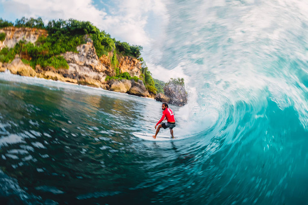April 18, 2019. Bali, Indonesia. Surfer ride on barrel wave. Professional surfing at big waves in Padang Padang - Foto, Imagen