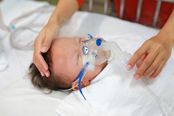 Baby has asthma and need nebulizations, Sick boy inhalation therapy by the mask of inhaler. Baby boy has a nasal congestion. Baby boy making inhalation with nebulizer. - Photo, Image