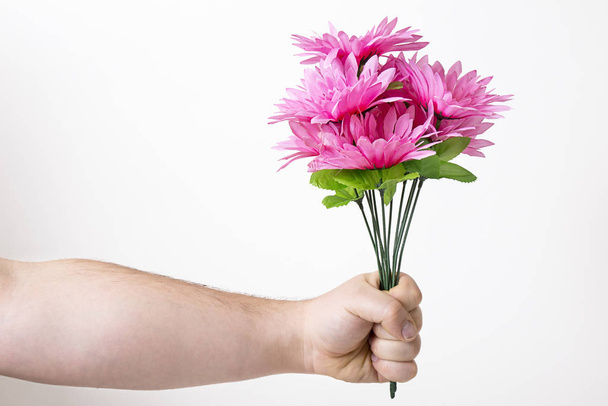 man arms holding a bouquet of pink fake flower - Fotografie, Obrázek