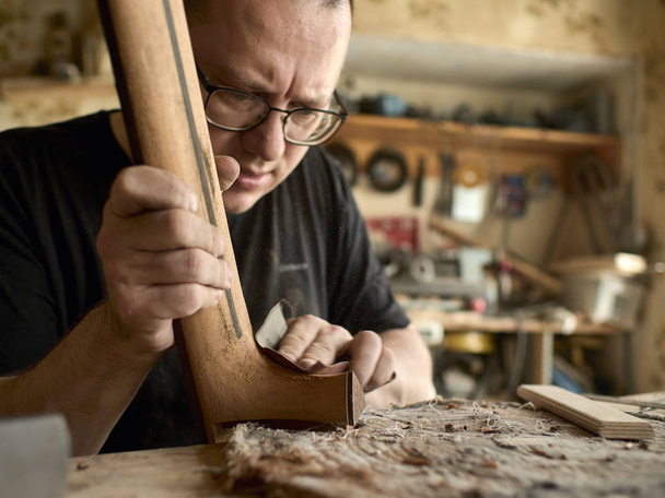 luthier polishes the body of classical guitar. - Photo, Image