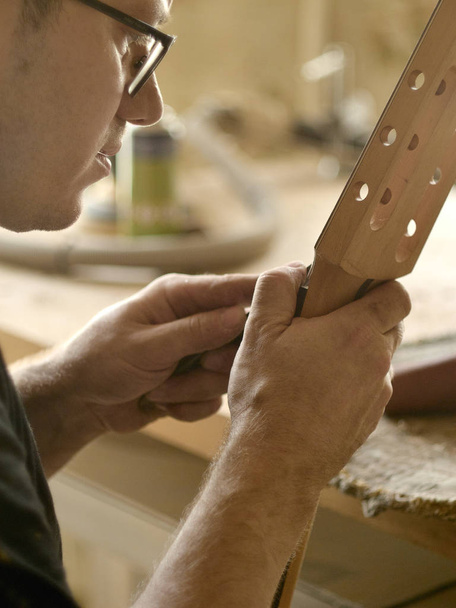 luthier is working on the neck of classical guitar. - Fotó, kép