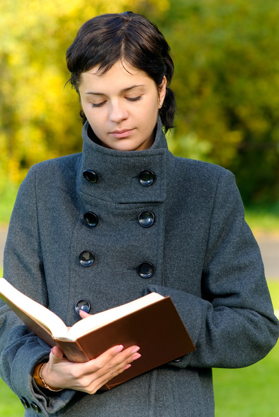 Chica en abrigo lee libro
 - Foto, Imagen