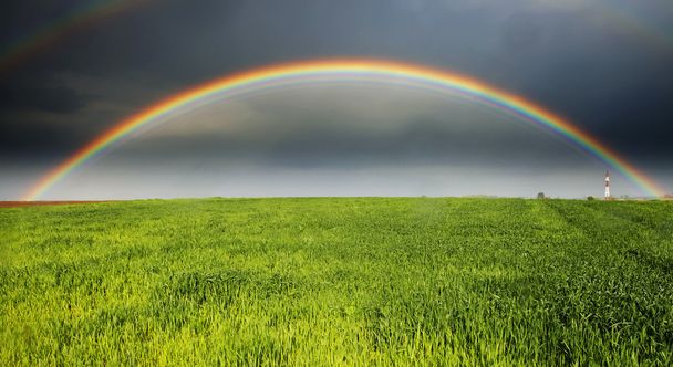 regenboog tegen een stormachtige lucht - Foto, afbeelding