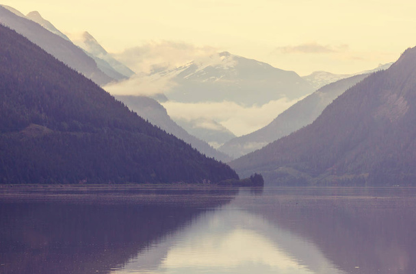 穏やかな水の中の岩の反射とカナダの山の湖で穏やかなシーン. - 写真・画像