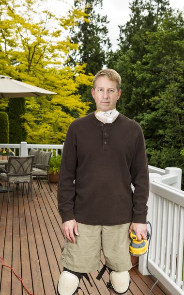 Mature man getting ready to work on outdoor deck - Foto, imagen