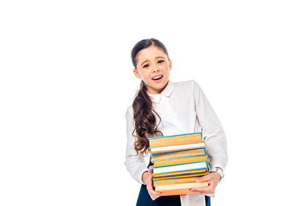schoolgirl in formal wear looking at camera and holding books Isolated On White with copy space - Foto, afbeelding