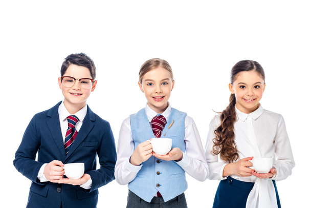niños de escuela felices que fingen ser empresarios con tazas de café aisladas en blanco
 - Foto, Imagen