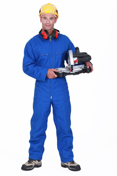Handyman holding a circular saw - Фото, зображення