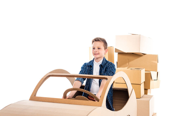 godny podziwu chłopiec gra z tekturowym samochodzie izolowane na białym z kopią przestrzeni - Zdjęcie, obraz
