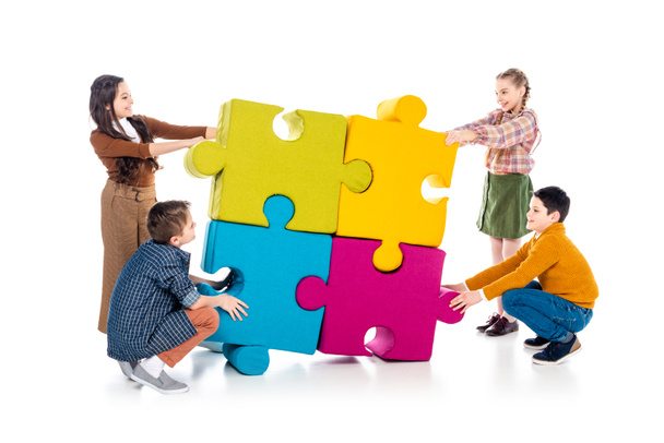 happy kids playing with jigsaw puzzle pieces on white  - Photo, Image