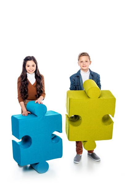 happy kids with jigsaw puzzle pieces looking at camera on white - Фото, изображение