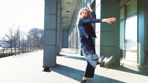 young blonde woman showing contemporary dance in sunlit street in slow motion - Filmagem, Vídeo