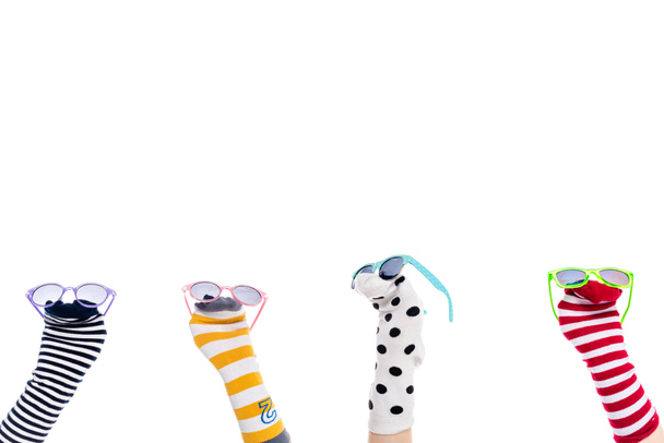 vue recadrée des personnes avec des marionnettes chaussettes colorées et des lunettes de soleil sur les mains isolé sur blanc
  - Photo, image