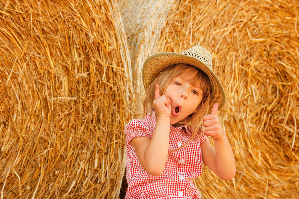 happy child on a field with bales harvest in autumn - Photo, Image