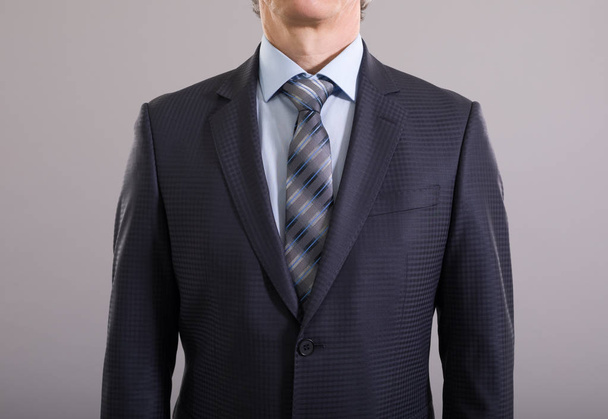 Ένας άντρας με κομψό κουστούμι σε ανοιχτόχρωμο φόντο. Ανδρική Μόδα. - Φωτογραφία, εικόνα