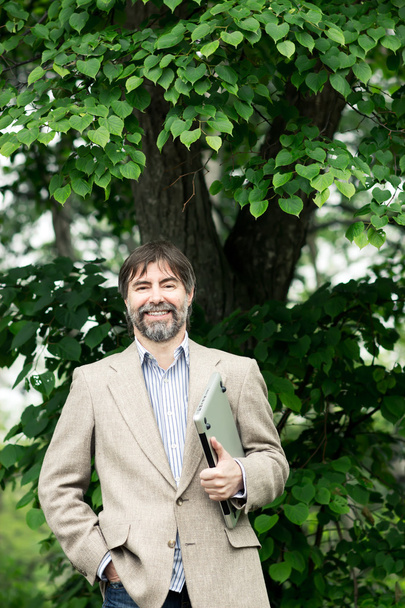 Portrait of happy middle-aged businessman holding notebook and s - Fotó, kép
