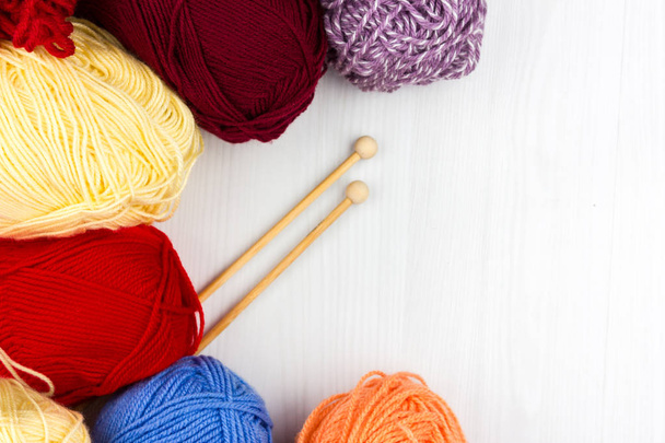 Flatlay of multicolored pastel knitting skeins of yarn and knitting needles on white background - Photo, Image