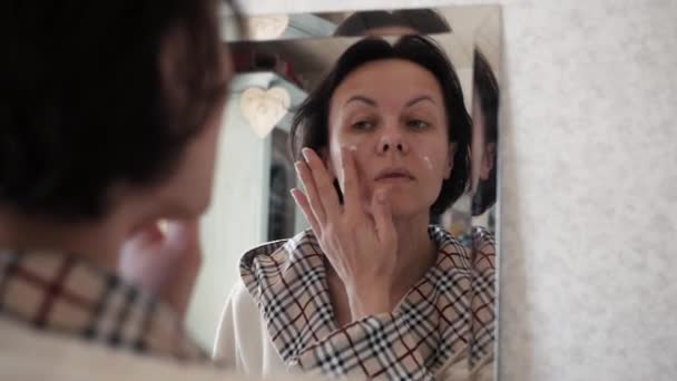 Portrait Of Beautiful Healthy Woman Putting Moisturizing Cream On Face. - Materiał filmowy, wideo