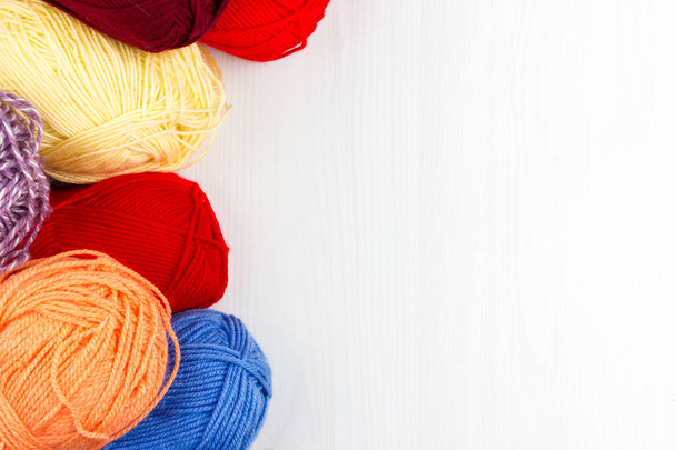 Flatlay de tricot pastel multicolore écheveaux de fil et aiguilles à tricoter sur fond blanc
 - Photo, image