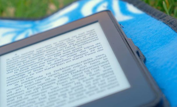 E-book no fundo da grama verde e folha azul
 - Foto, Imagem