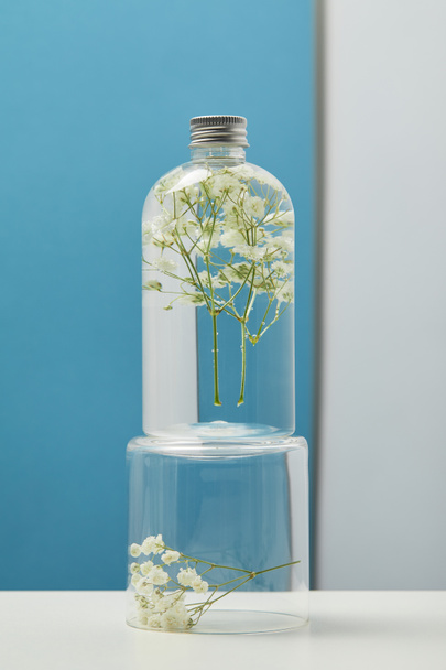 prodotto cosmetico biologico con fiori di campo bianchi in bottiglia trasparente
  - Foto, immagini