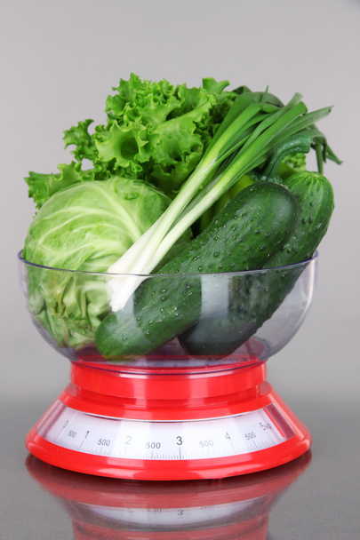 Fresh vegetables in scales on gray background - Foto, afbeelding