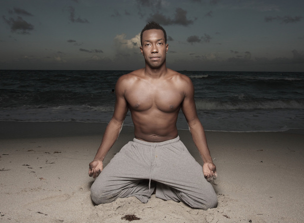 man uitvoeren van yoga op het zand - Foto, afbeelding
