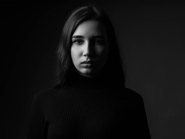 Portrait of a sad young woman. Black and white. Low key - Zdjęcie, obraz