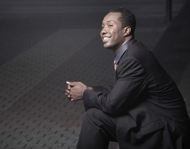 fiatal afro-amerikai üzletember ülnek, és mosolyogva - Fotó, kép