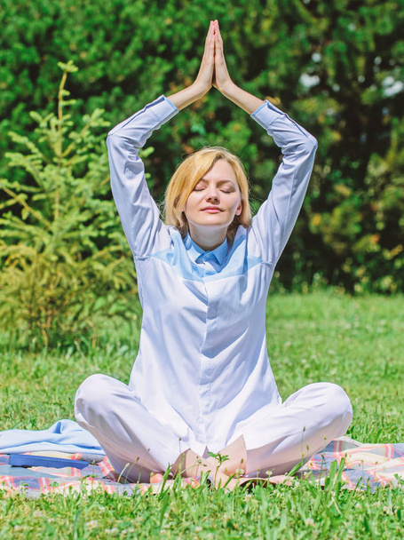 Girl meditate on rug green grass meadow nature background. Woman relaxing practicing meditation. Every day meditation. Reasons you should meditate every day. Find minute to relax. Clear your mind - Photo, Image