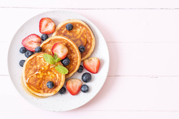 pancake with fresh blueberries, fresh strawberries and honey - Foto, imagen