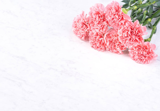 Design concept - Beautiful bunch of carnations on marble white background, top view, copy space, close up, mock up. Mothers day gift idea inspiration. - Foto, Imagem