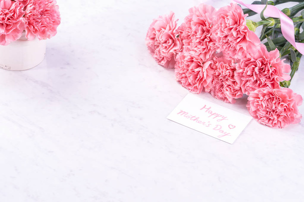 Design concept - Beautiful bunch of carnations on marble white background, top view, copy space, close up, mock up. Mothers day gift idea inspiration. - Φωτογραφία, εικόνα