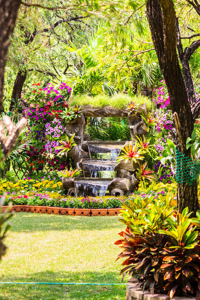 Waterfall flows in cozy home flower garden - Photo, Image