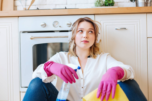 Pleasant young woman having a break from cleaning - Foto, afbeelding