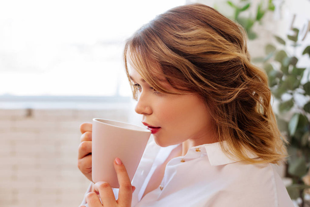 Nice attractive woman taking a sip of tea - Foto, Imagen