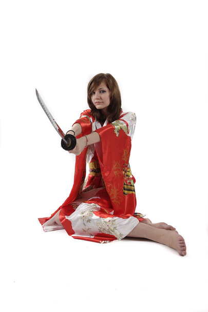 french young girl geisha in red silk kimono with japanese sword - Foto, Imagen