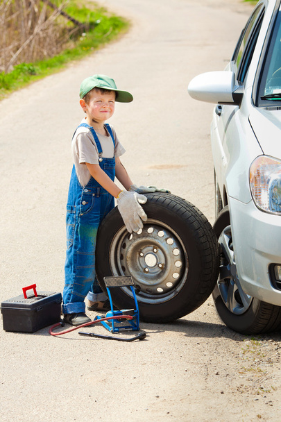 мальчик меняет колесо
 - Фото, изображение