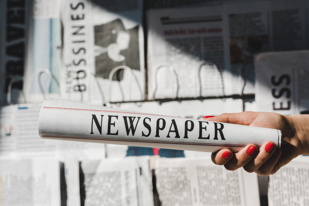 cropped view of woman holding daily print newspaper - Zdjęcie, obraz