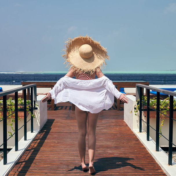 Donna in costume da bagno a righe sul patio della spiaggia
 - Foto, immagini