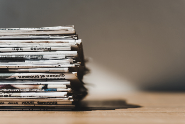 diferentes jornais impressos em pilha na mesa de madeira com sombra
 - Foto, Imagem