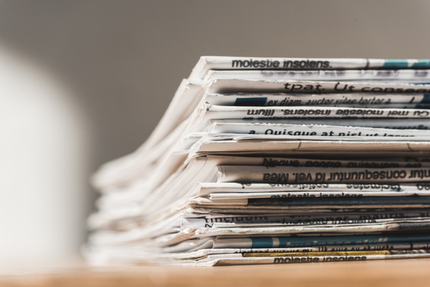 selective focus of different print newspapers in pile on wooden table  - Фото, зображення