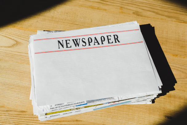 pile of newspapers with copy space on wooden table - Photo, Image