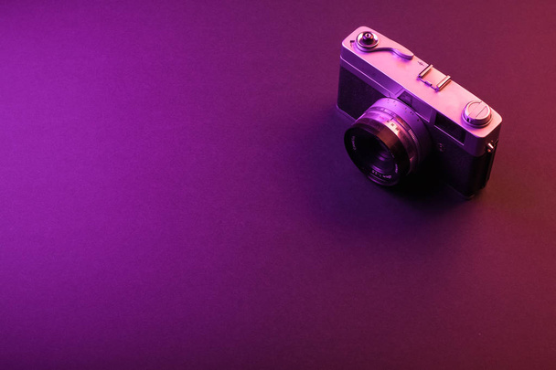 Vintage kamera izolátum a fekete háttér és a lila fény. Szóközszöveg - Fotó, kép