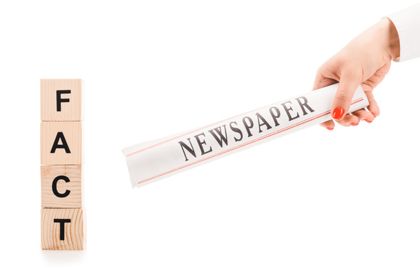 vista cortada da mulher segurando jornal perto de blocos de madeira com letras de fato isolado no branco
 - Foto, Imagem