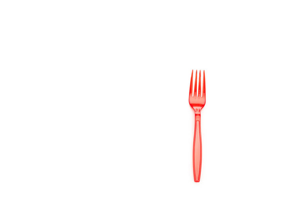 tenedor brillante de plástico rojo aislado en blanco con espacio de copia
 - Foto, imagen