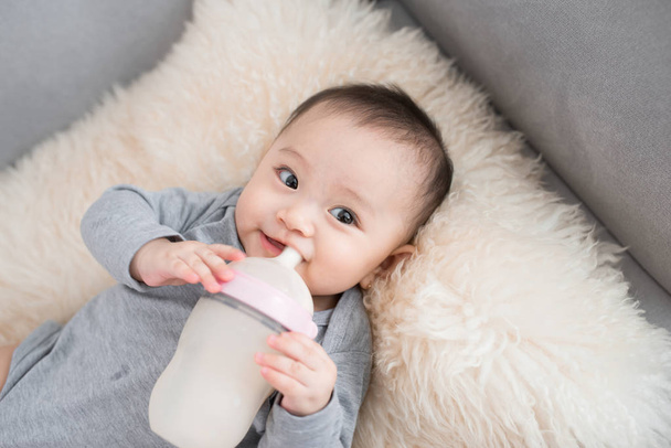Asya bebek bebek süt şişeden, doğumdan sonra 9 ay yeme. - Fotoğraf, Görsel