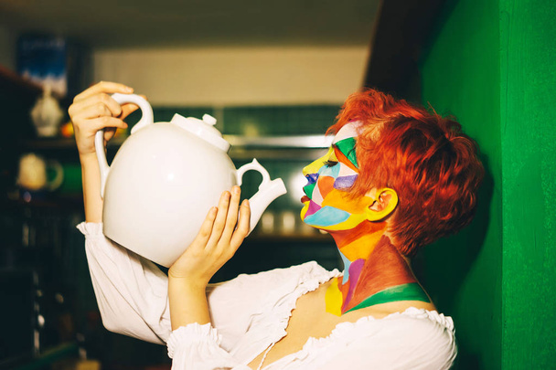 A woman with multi-colored make-up and orange hair - Фото, зображення